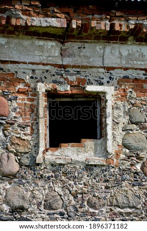 stone wall of an old historic building with a former window opening
