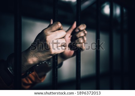 Portrait of women desperate to catch the iron prison,prisoner concept,thailand people,Hope to be free,If the violate the law would be arrested and jailed. Royalty-Free Stock Photo #1896372013