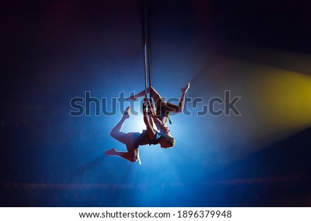 Circus actress acrobat performance. Two boys perform acrobatic elements in the air Royalty-Free Stock Photo #1896379948