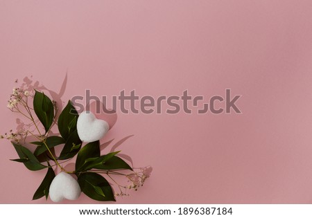 Hearts and green leaves on pink background. Wedding and love concept. Valentines's day aesthetic.