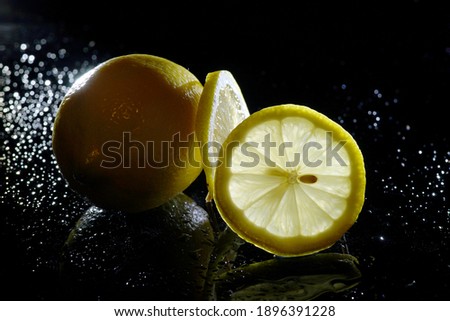                         lemon and lemon slices on black background       