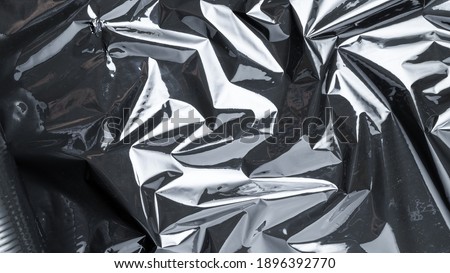 Cellophane wrap. Black shiny film bag pattern. Transparent dark cellophane texture for packaging, product protection