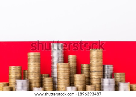 Stacks of coins on the background of polish flag. Concept of economy, banking and trade in Poland.