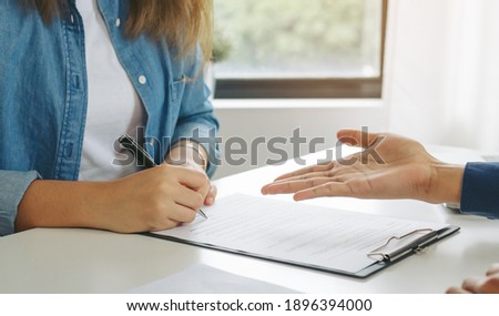 Close up hand of tenant woman use the pen for sign on contract rental house on paperwork after a successful agreement with landlord or realtor.