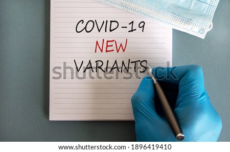 Covid-19 new variants symbol. Hand in blue glove with pen, white card. Concept words 'Covid-19 new variants'. Medical face mask. Medical and COVID-19 pandemic and new variants concept. Copy space. Royalty-Free Stock Photo #1896419410