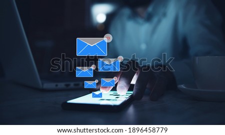 Business man holding smartphone with emails.
