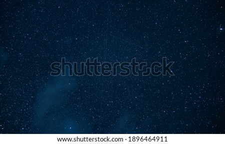 View of a starry night in the middle of the Vladeasa mountains in Romania. The stars, satellites and comets are present to give us the best spectacle with a bluish sky in the background.
