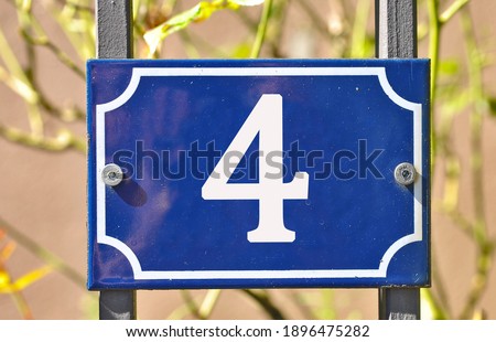 
A blue house number plaque, showing the number four (4) 