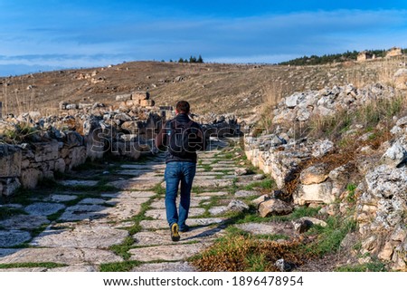 Man walking in ruins of the ancient city of Hierapolis in Turkey