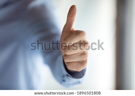 Close up hand view, businessman entrepreneur showing thumbs up gesture, excited by business achievement, client recommending good service, employee intern satisfied by job, career, great news