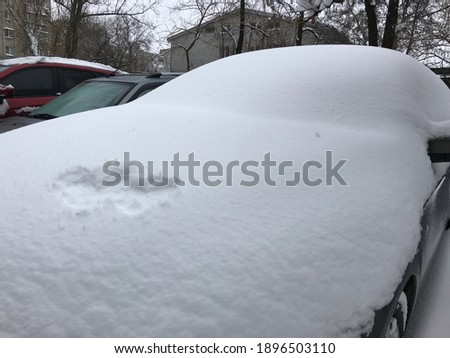 Romantic drawings on the snow surface on the car. A picture of two hearts drawn by fingers on the car in the winter. front trunk decorated with shape of two hearts. 