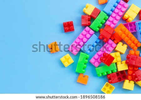 Plastic building blocks on blue background.