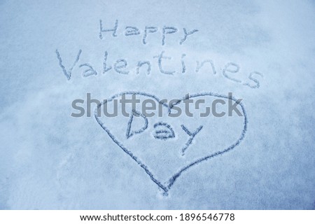 inscription - happy valentines day and painted heart in the snow and ice. background for Valentines Day. background for lovers