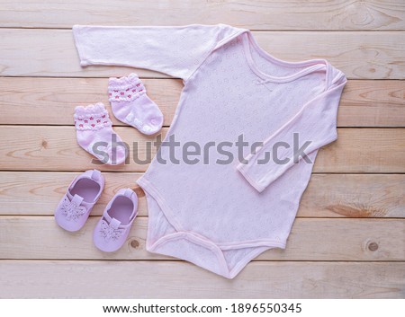 The clothes for kids for babies set with accessories on the wooden table.