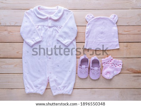 The clothes for kids for babies set with accessories on the wooden table.
