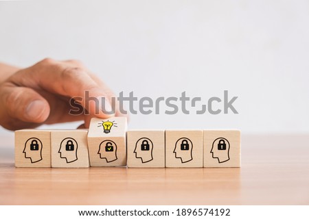Business concept of creative idea and innovation. Hand picked wooden cube block with unlock icon (new idea) and head human symbol have lock idea. Royalty-Free Stock Photo #1896574192