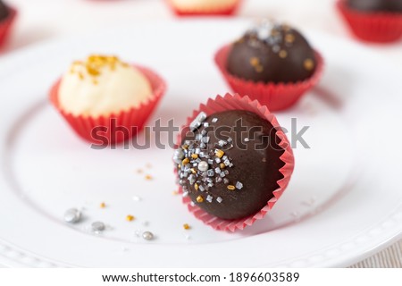 Dark and white chocolate coated almond London cookies in red paper cup