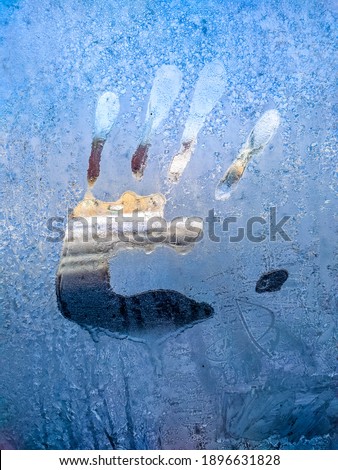 Palm print on frozen glass
