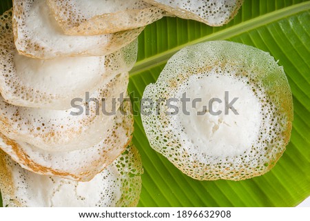Appam or kallappam  or paalappam, tasty delicious  breakfast item in south india or malabar area,made using raw rice and a good combination for veg and non veg currys ,placed on fresh  banana leaf.