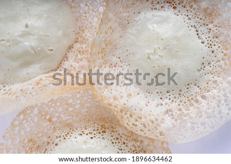 Appam or kallappam  or paalappam, tasty delicious  breakfast item in south india or malabar area,made using raw rice and a good combination for veg and non veg currys ,placed on a  white background.