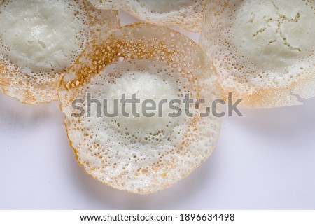 Appam or kallappam  or paalappam, tasty delicious  breakfast item in south india or malabar area,made using raw rice and a good combination for veg and non veg currys ,placed on a  white background.