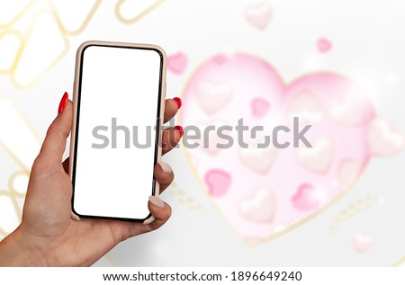 Happy Valentines Day. A woman holds a mockup of a smartphone in her hands on the background of a hearts