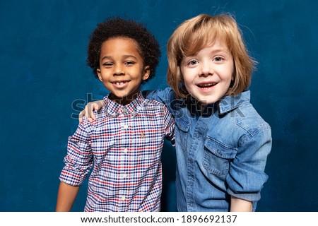 Portrait of two happy laughing multiracial friends schoolboys. Multiethnic friendship of two kids, joyful black african american embracing caucasian boy in tolerance unity, anti racism concept.
