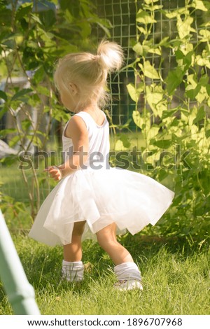 Little girl ballerina in a tutu in the garden