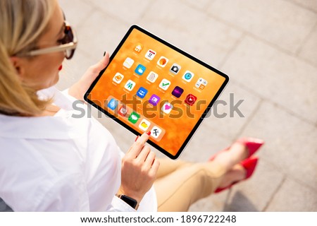Woman using tablet with colorful home screen full of sample app icons