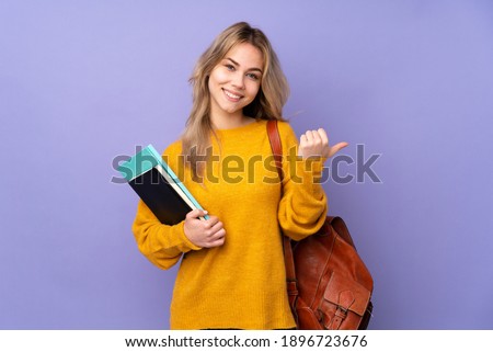 Teenager Russian student girl isolated on purple background with thumbs up gesture and smiling Royalty-Free Stock Photo #1896723676