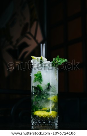 Green background beverage. High quality photo Mojito with ice and mint