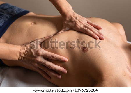 Woman physiotherapist does session to man. visceral ostropathy Royalty-Free Stock Photo #1896725284
