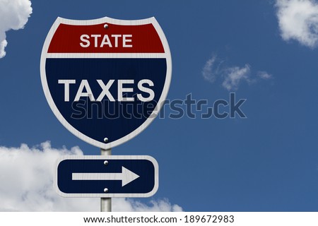 State Taxes this way, Blue and Red Interstate Sign with word State Taxes and an arrow with sky background 