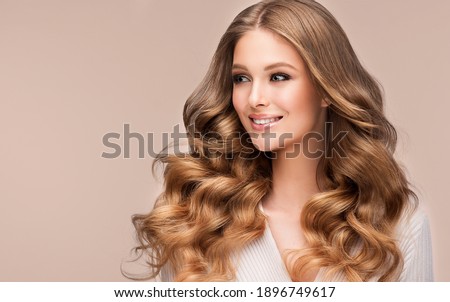 Beauty blonde girl with long  and   shiny wavy  hair .  Beautiful   woman model with curly hairstyle . Fashion, cosmetics and makeup Royalty-Free Stock Photo #1896749617