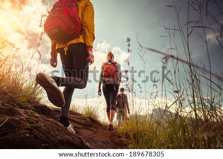 Hikers with backpacks walking in mountains at sunny day Royalty-Free Stock Photo #189678305