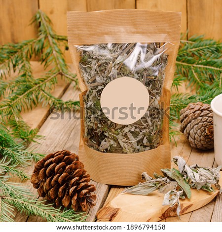 Dried herbs in craft packaging on natural wooden background. Space for text. Healthy herbal tea