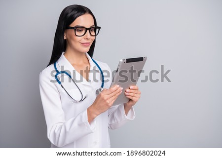 Photo of confident shiny woman therapist dressed white uniform eyewear holding modern gadget isolated grey color background
