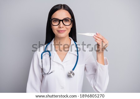 Photo of doctor lady hold thermometer wear spectacles stethoscope white uniform isolated grey color background