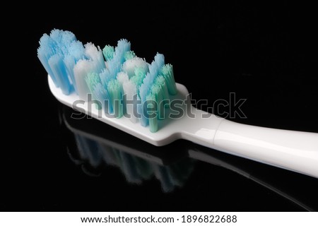 Clean new toothbrush on black mirror background close-up macro photography
