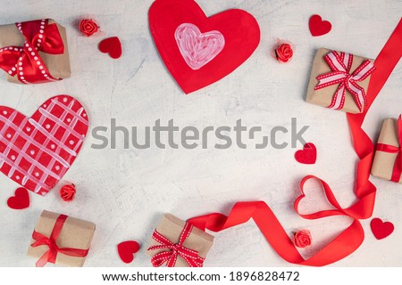 Heart from a red ribbon, gifts with a red ribbon and red hearts on a white stone background. Valentine's day background. Valentine's day concept. Flat lay. View from above.