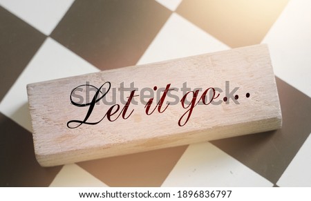 Let It Go wooden sign with a chess on background. Phylosophy forgiveness concept.