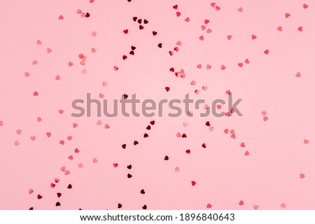 Pink background with glitter hearts for valentine's day. Beautiful wrapping paper or background for a postcard. Place for text, banner for website