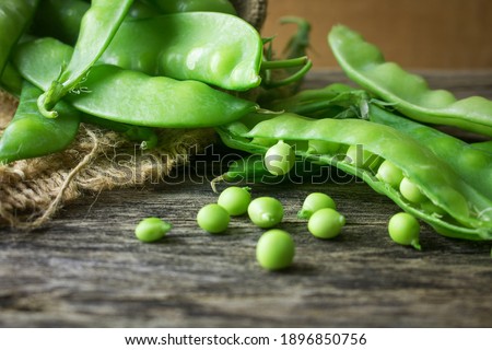 Pile of snow peas on wood background. Snow peas, also known as Chinese sugar peas, are excellent sources of vitamin C and a good source of folic acid. Royalty-Free Stock Photo #1896850756