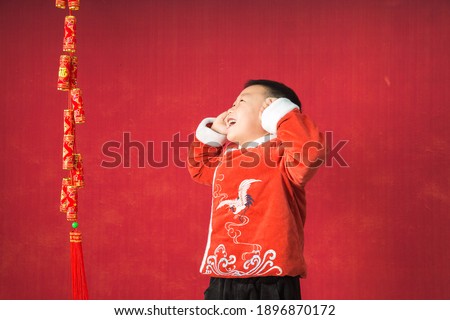 Asian Chinese boys wear red cotton-padded jackets indoors to celebrate Chinese New Year