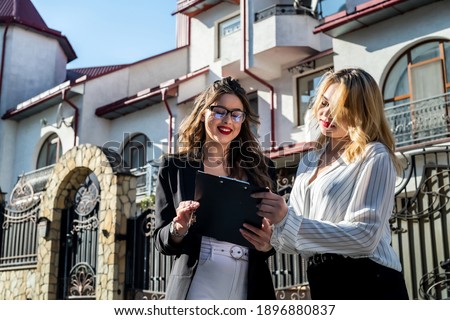 buyer and realtor signs an agreement to buy an apartment  of a multi-storey building on the background