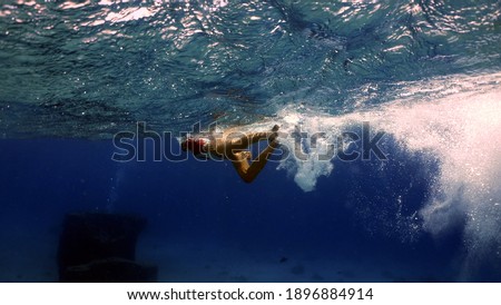 Diver makes a snorkeling swim in the Red Sea, view from the underwater.