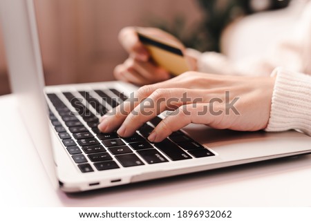 Close up of woman hands with credit card typing laptop. Online shopping at Christmas, Valentine day or birthday holidays. Freelance girl woking from home office Royalty-Free Stock Photo #1896932062