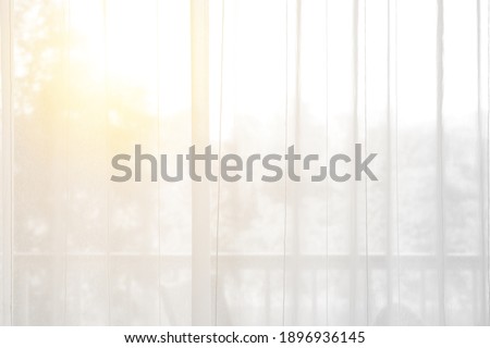 airy or thin and transparent white curtain with texture for see through and soft light on balcony window and close in room for home or hotel interior decor on morning warm sunlight for background Royalty-Free Stock Photo #1896936145