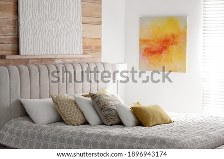 Comfortable bed with soft color pillows indoors