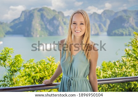 Attractive woman in a dress is traveling in Halong Bay. Vietnam. Travel to Asia, happiness emotion, summer holiday concept. Picturesque sea landscape. Ha Long Bay, Vietnam